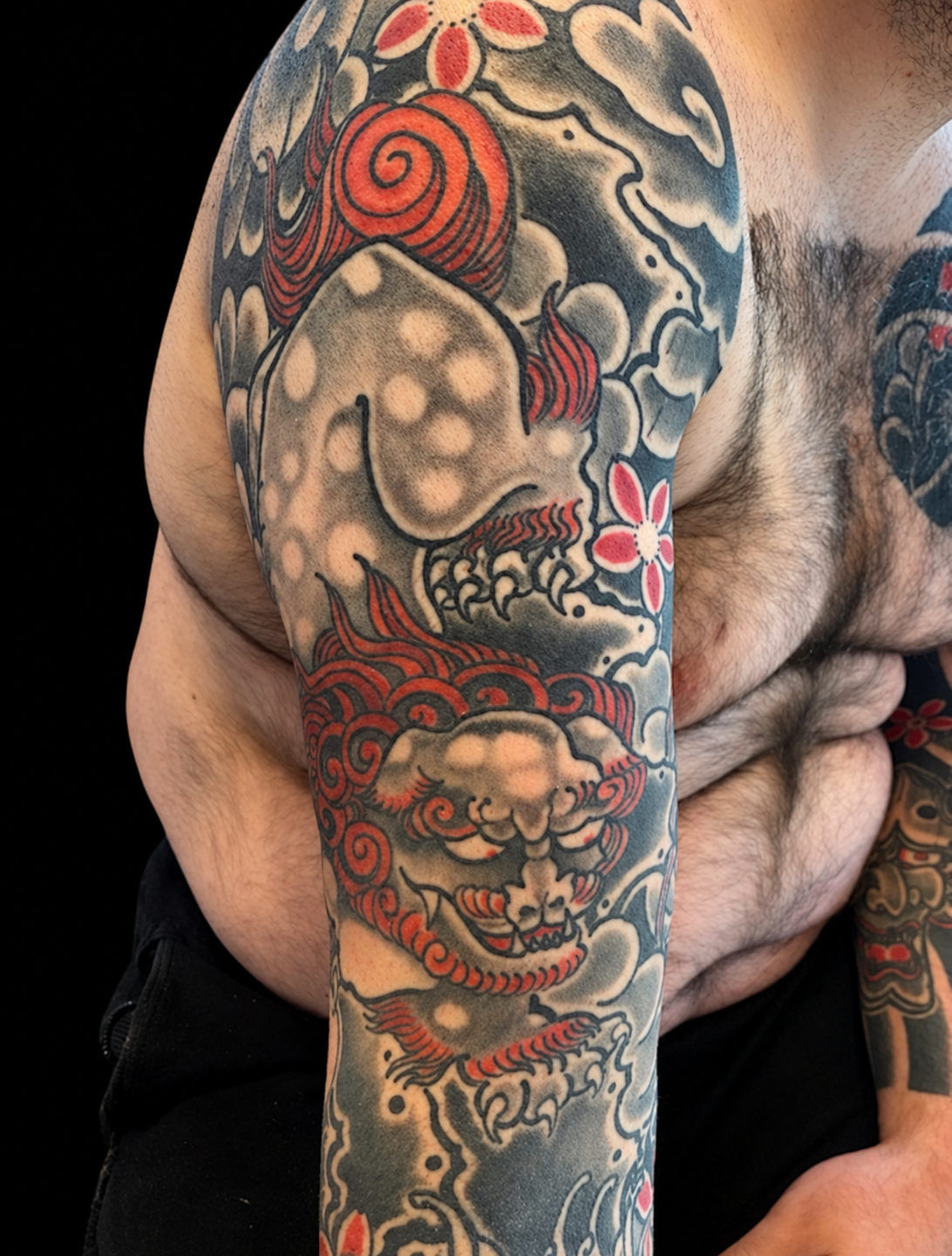 Japanese shishi sleeve tattoo on a solid black background
