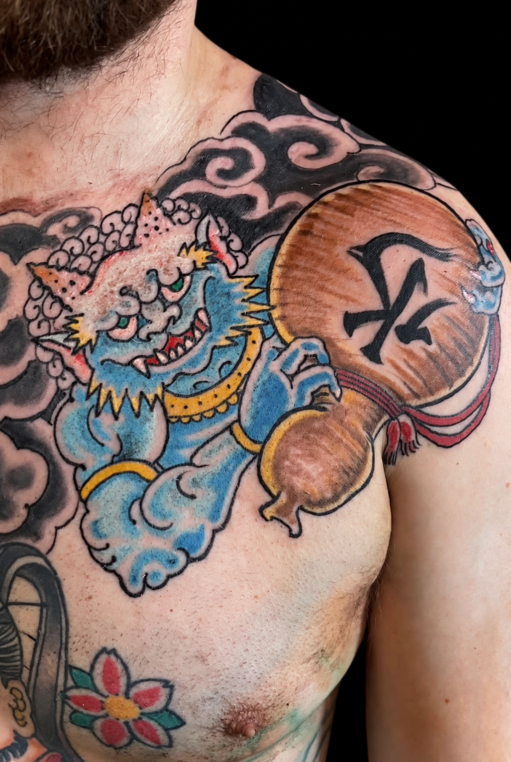 Blue Japanese shishi chest tattoo with waves and peonies