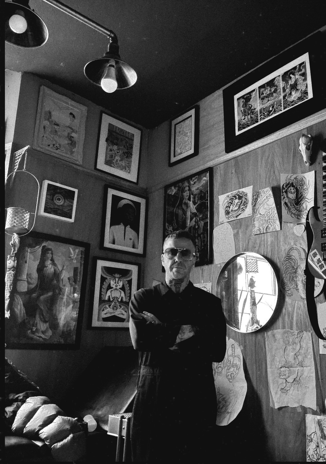 Black-and-white portrait of Roddy McLean with his arms crossed in the tattoo studio