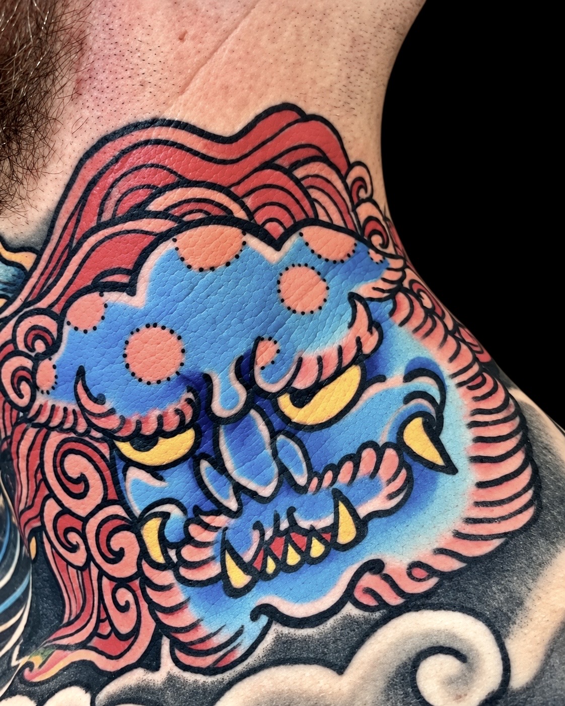 Blue shishi chest tattoo with red mane