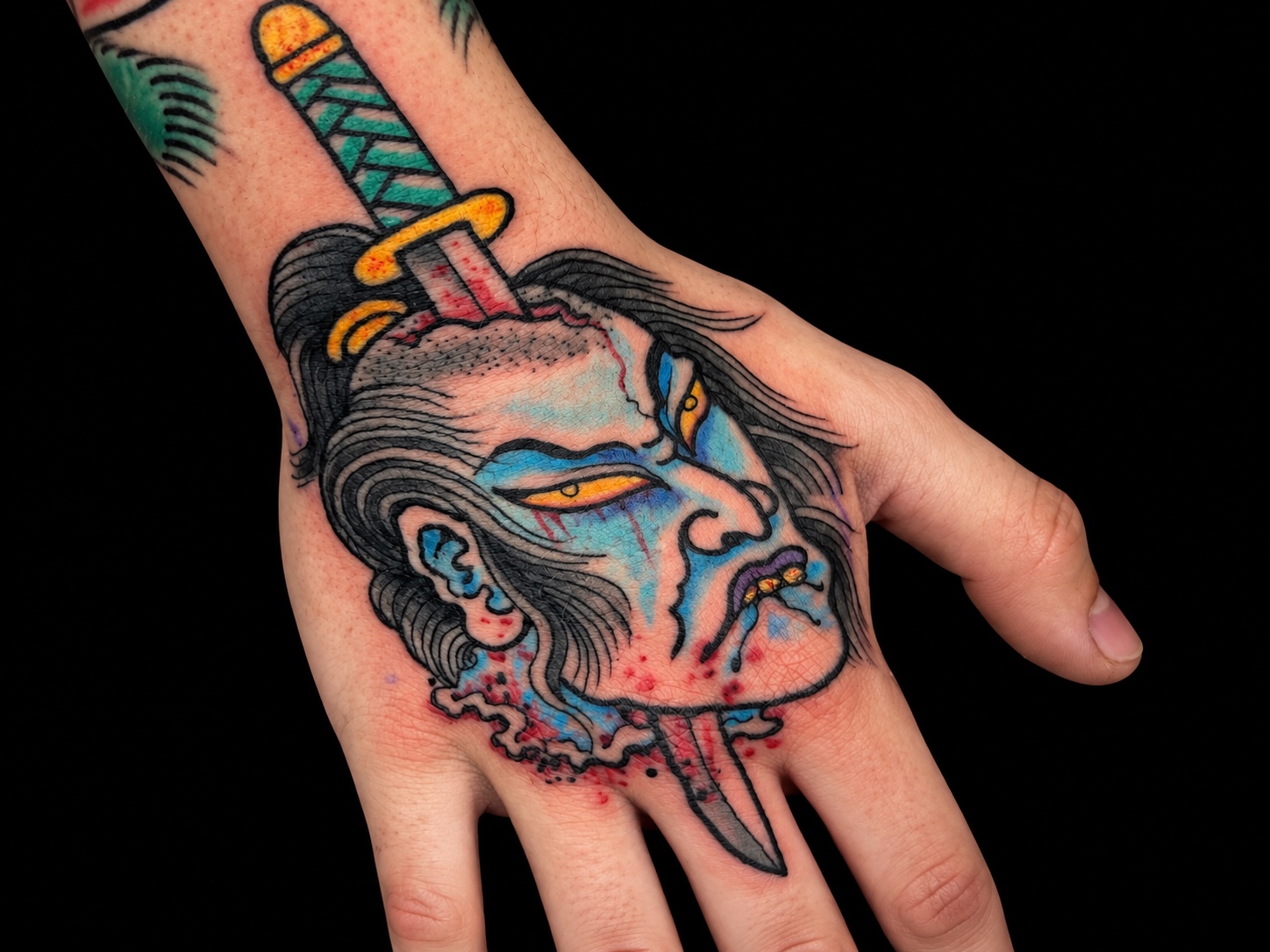 Blue namakubi and sword hand tattoo