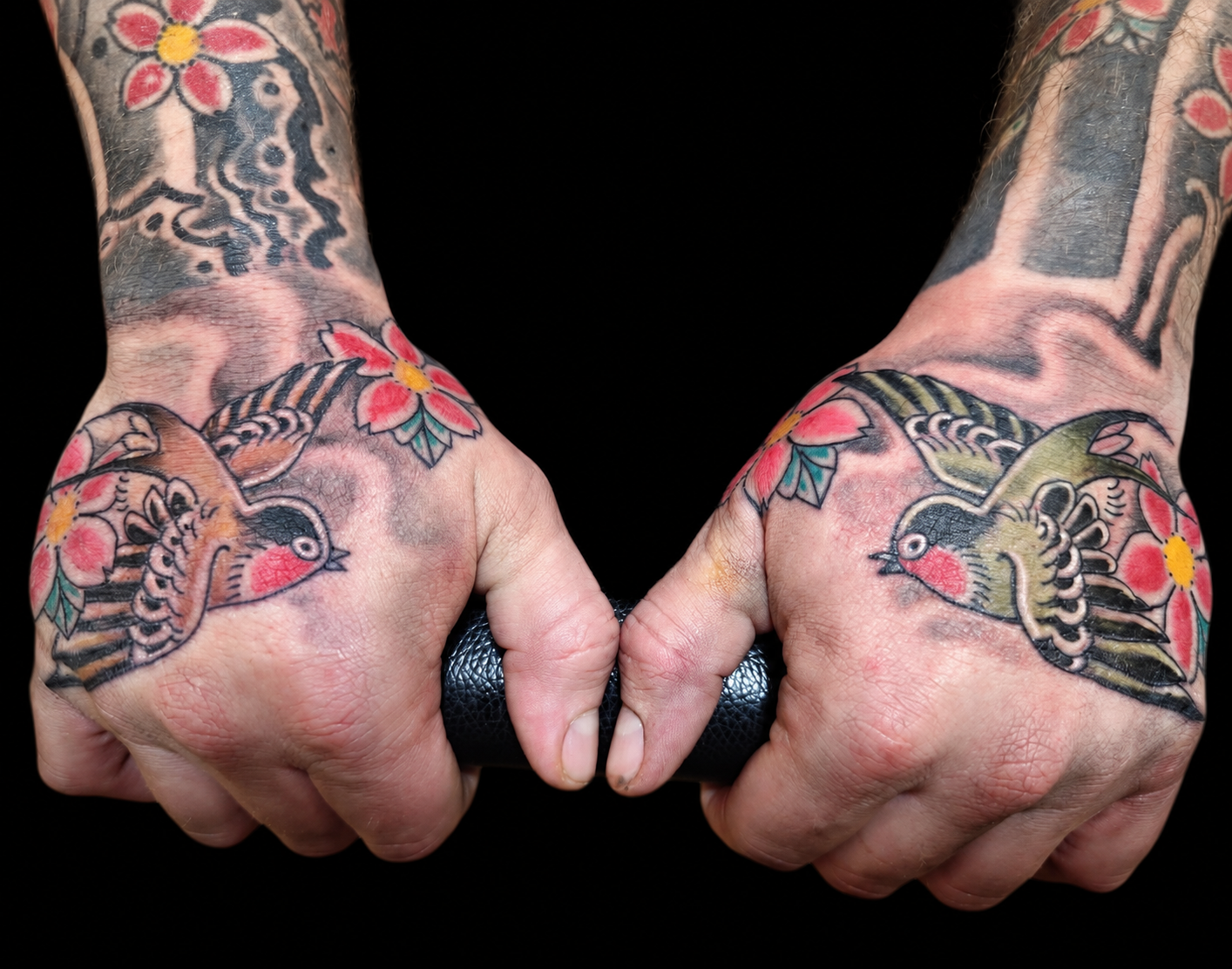 Pair of Japanese hand tattoos displayed on a black gallery background