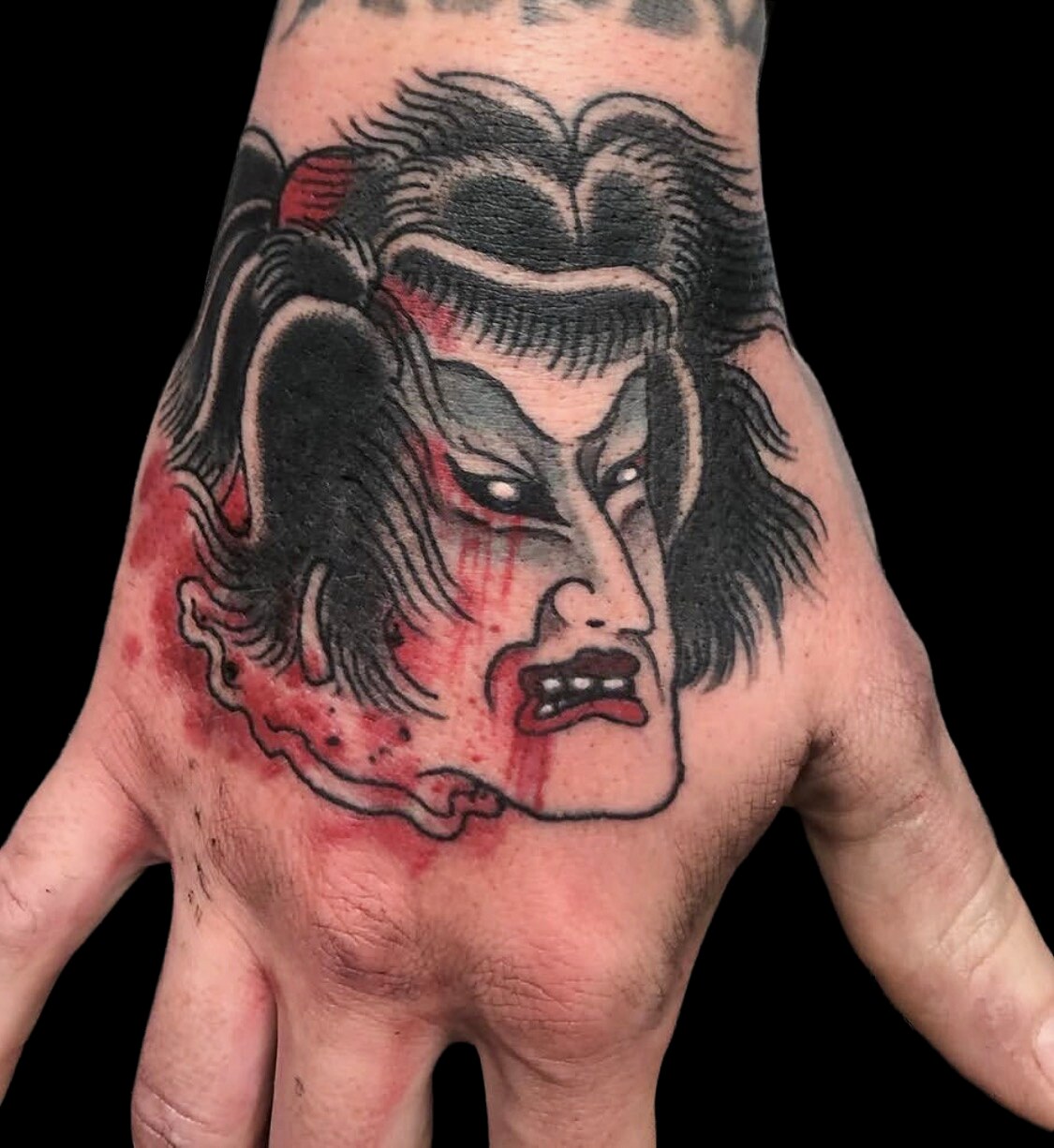 Japanese warrior head hand tattoo in black and red