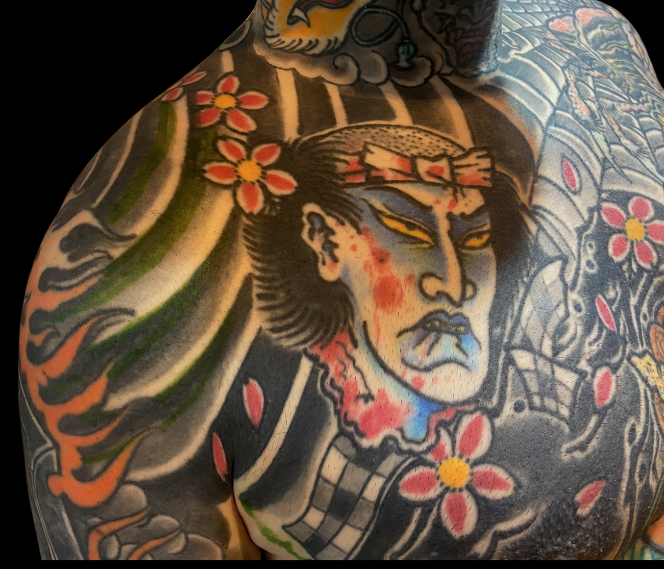 Japanese samurai chest tattoo with wind bars and cherry blossom on a solid black background