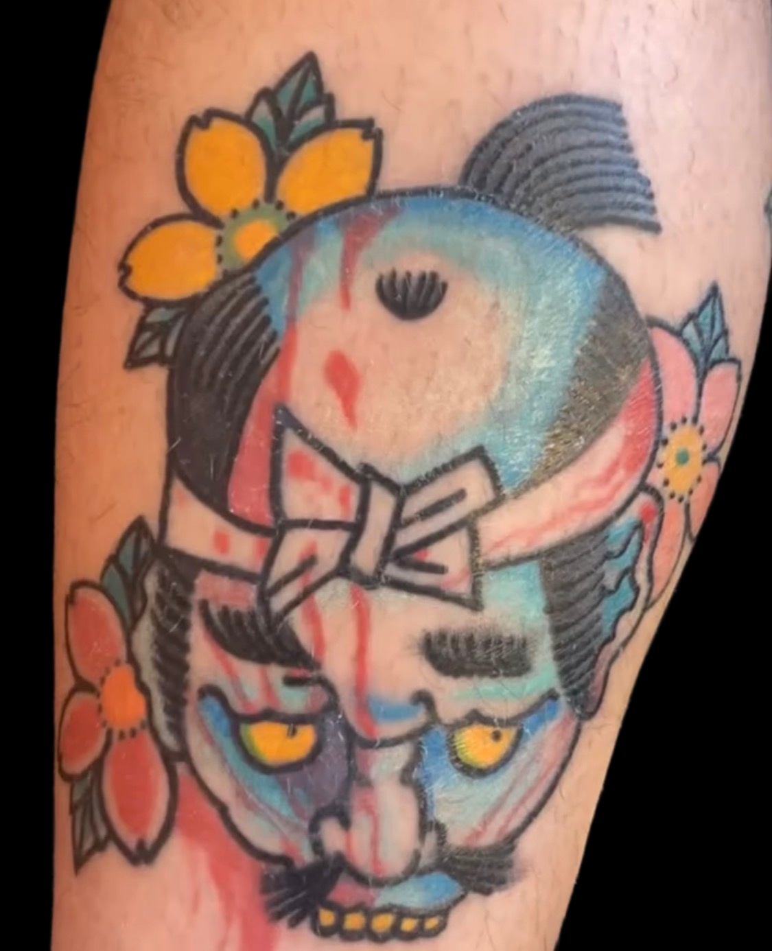 Colour Japanese severed head tattoo with flowers on a solid black background
