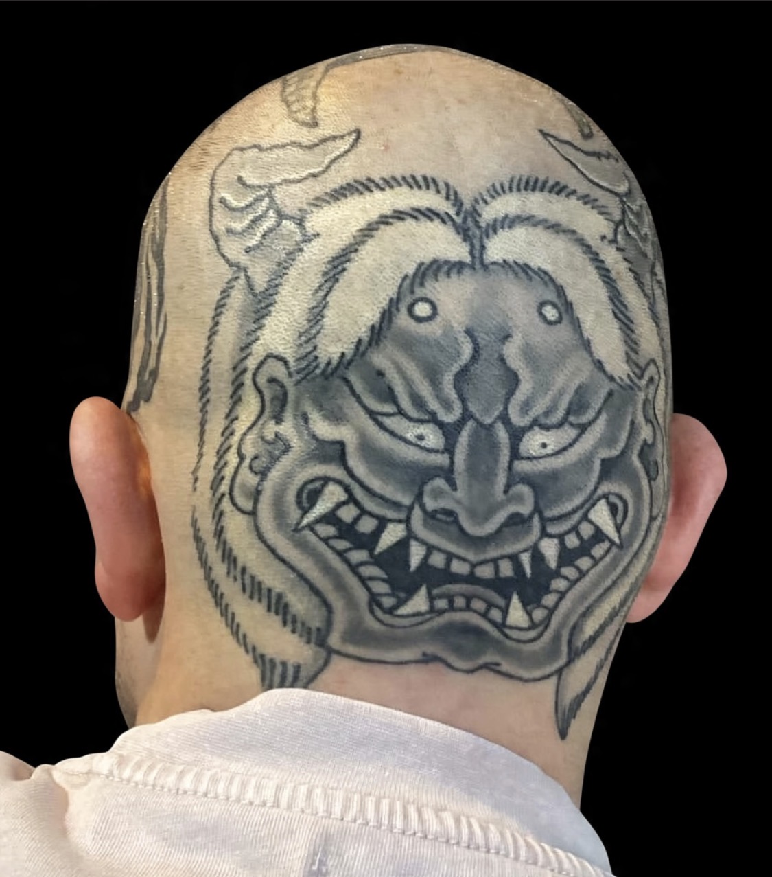 Black and grey tiger head tattoo displayed on a black gallery background